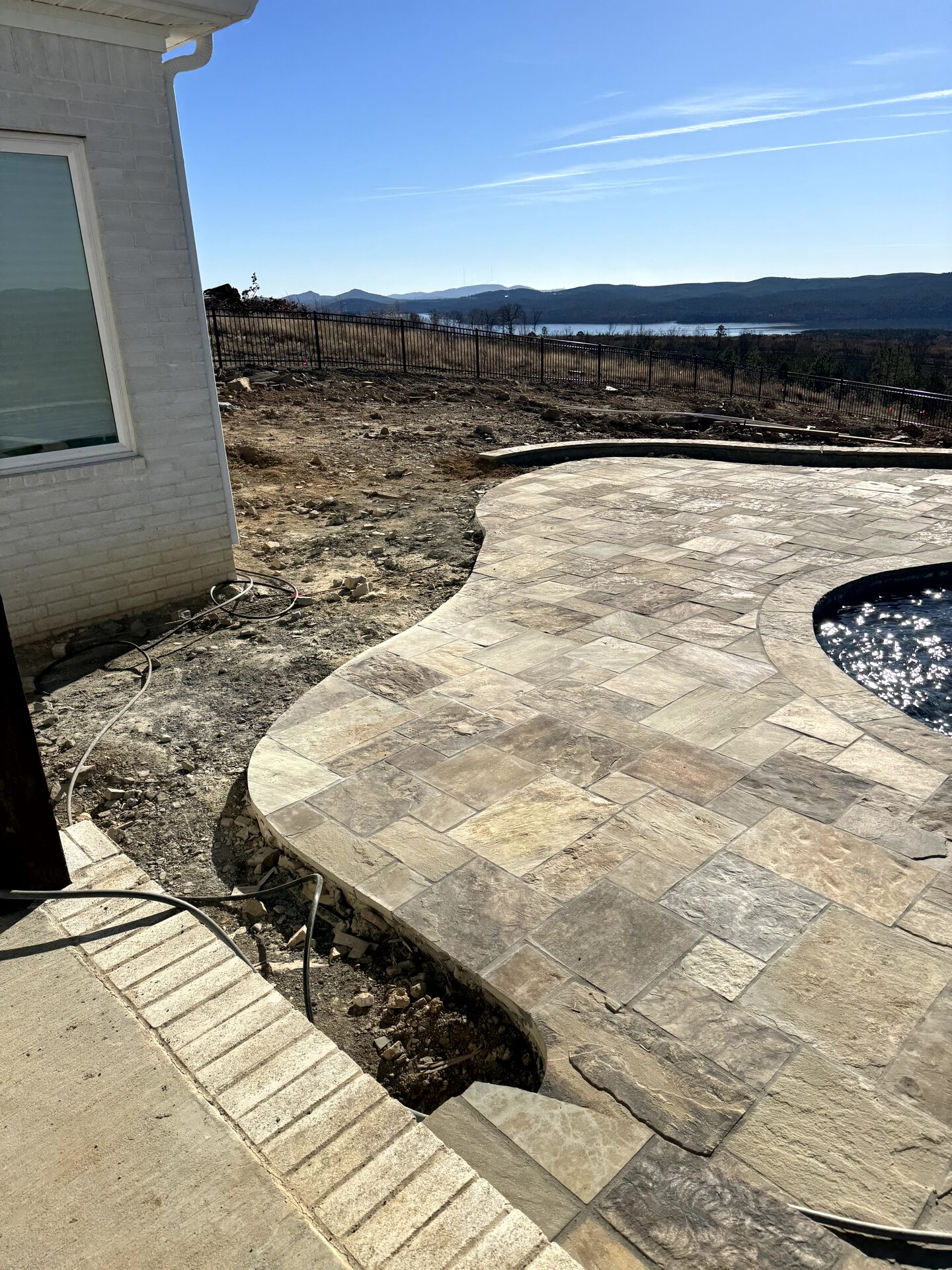 Pool and stone deck with lake views
