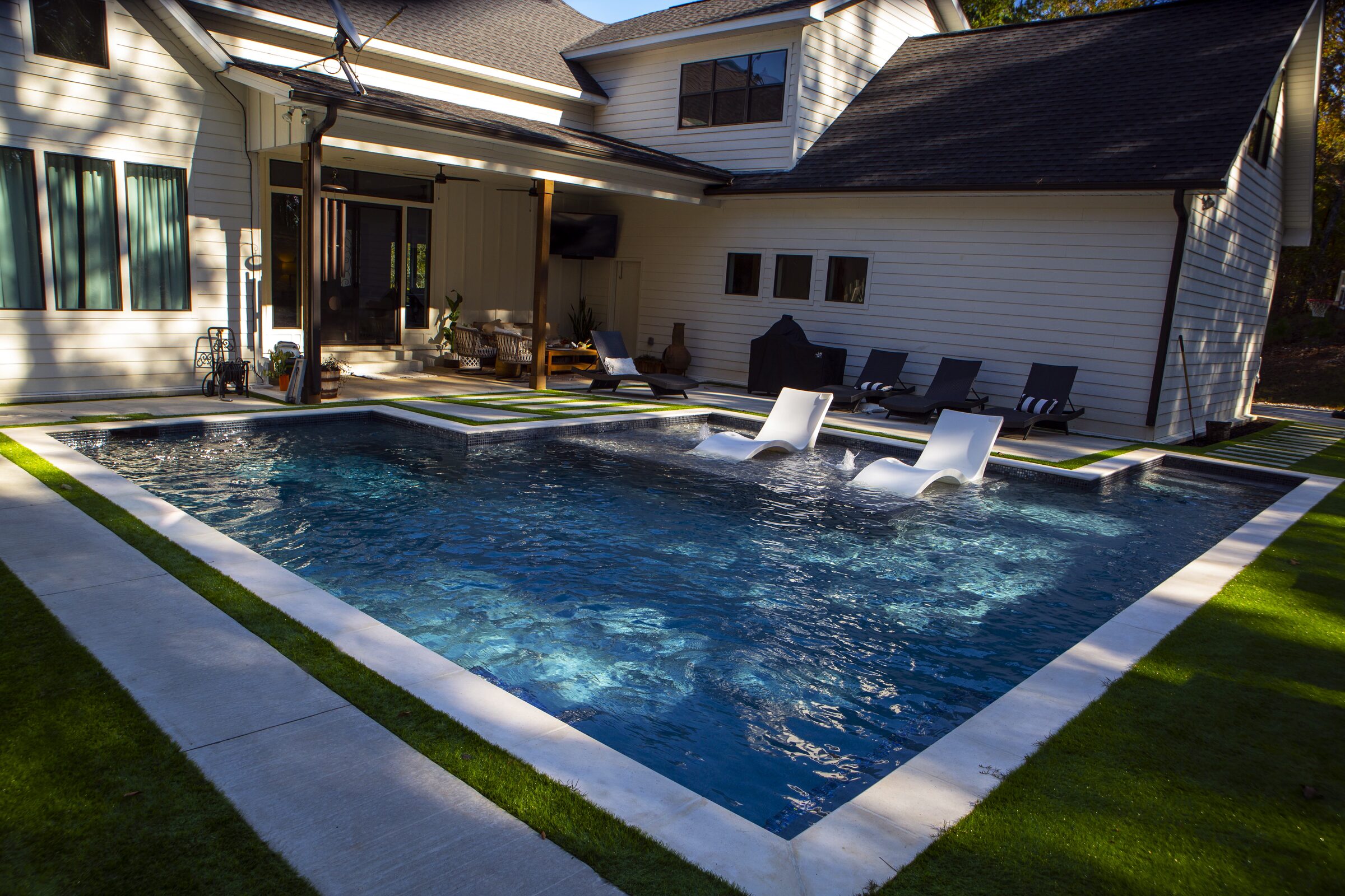 Wide view from the home — limestone deck wraps the pool