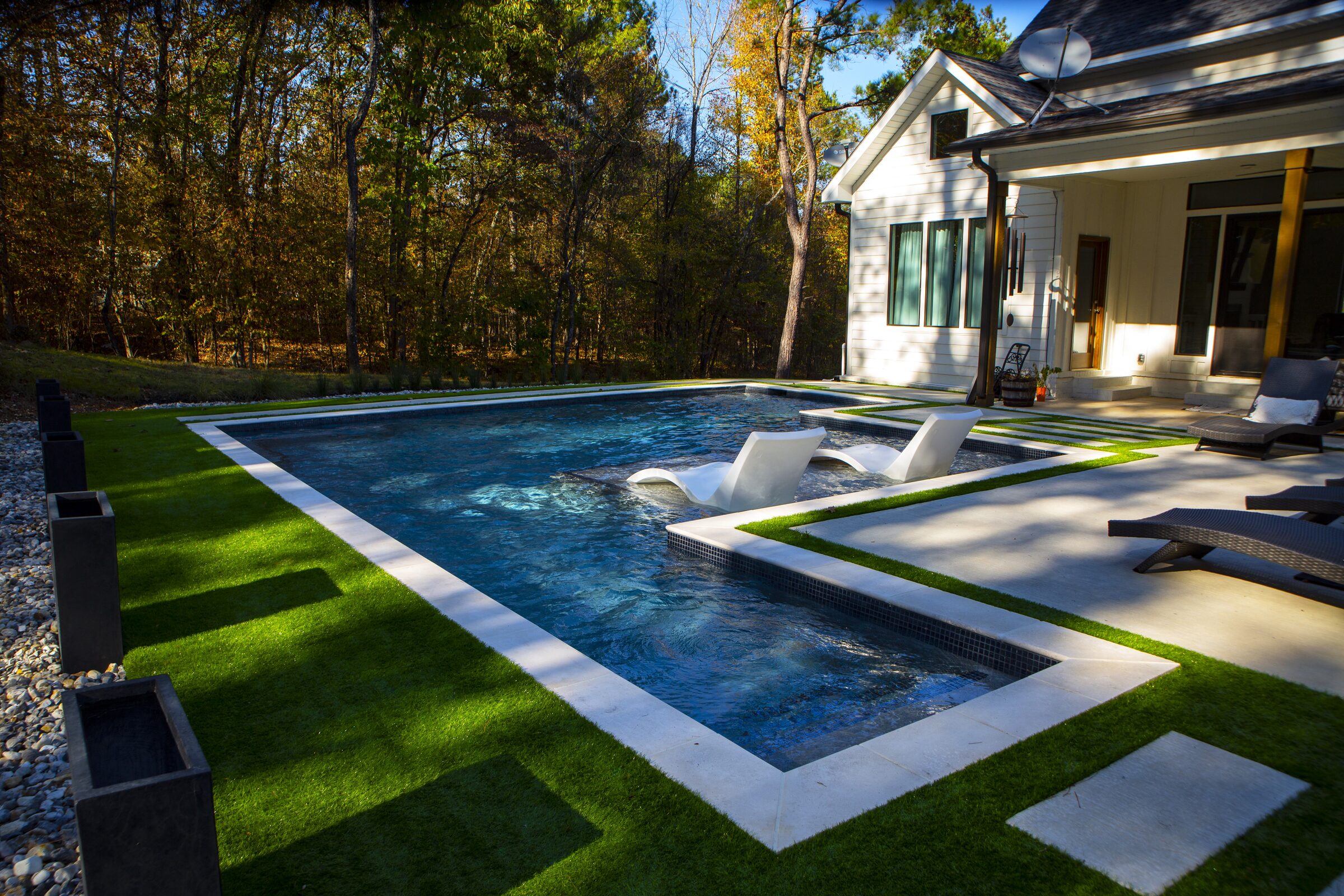 Modern lines with in-pool loungers and astro-turf surround