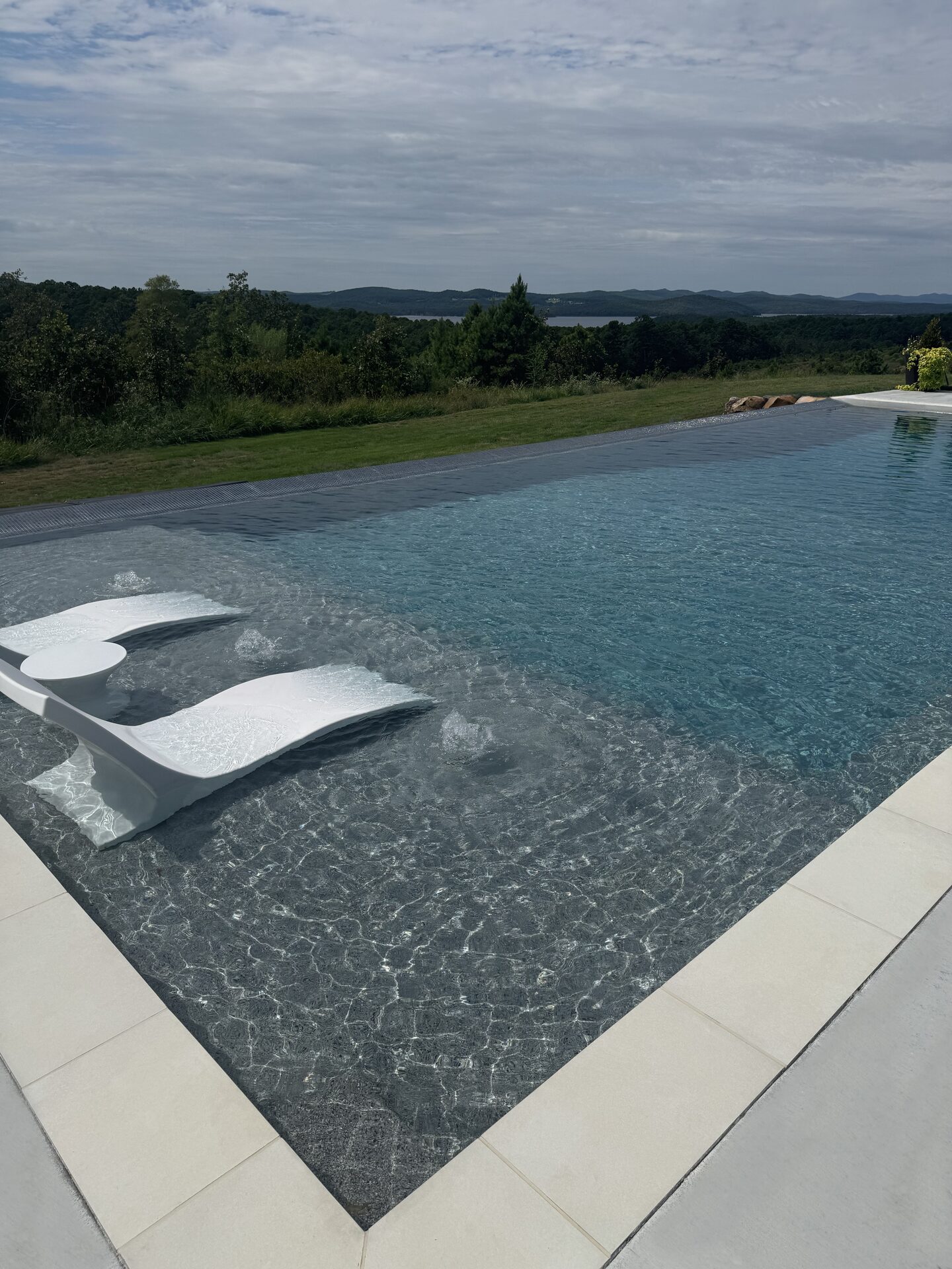 In-pool loungers with hillside backdrop