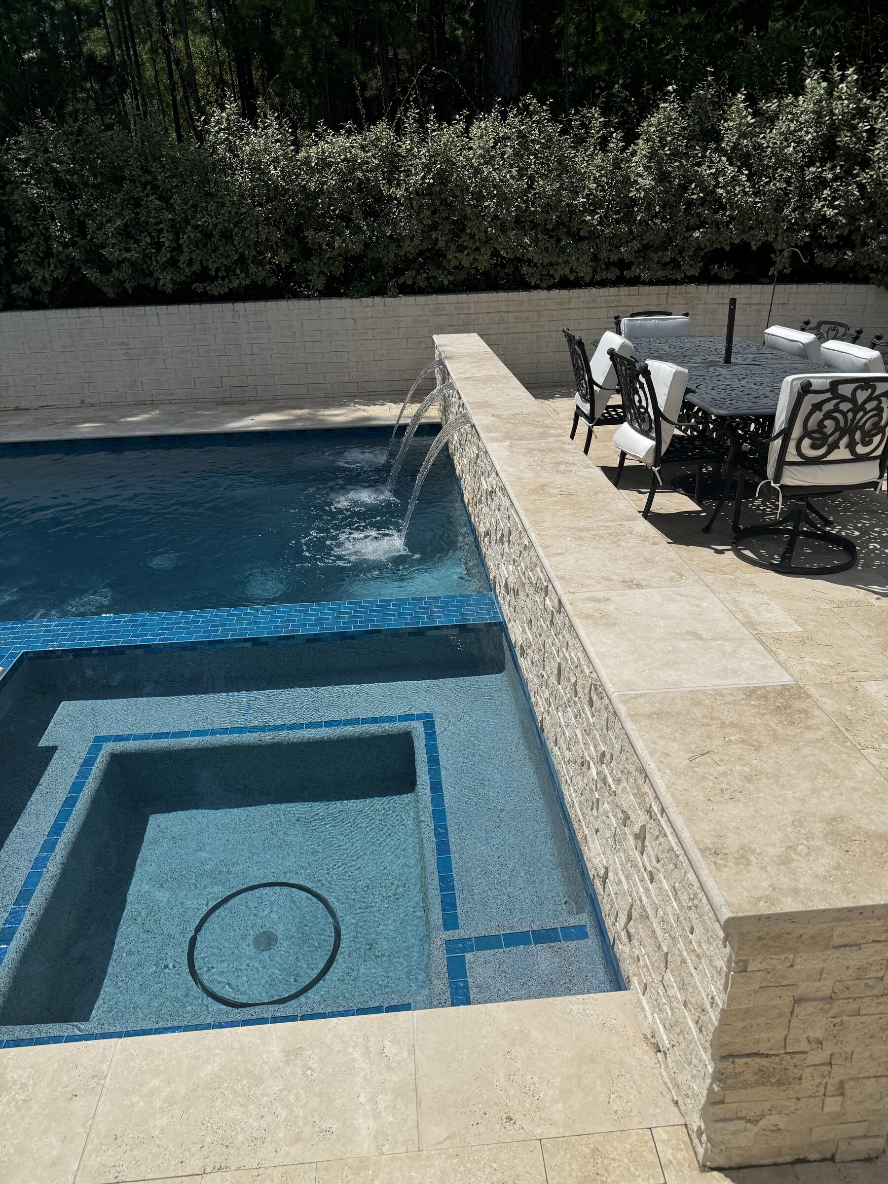 Elevated view — pool tucked into the travertine patio