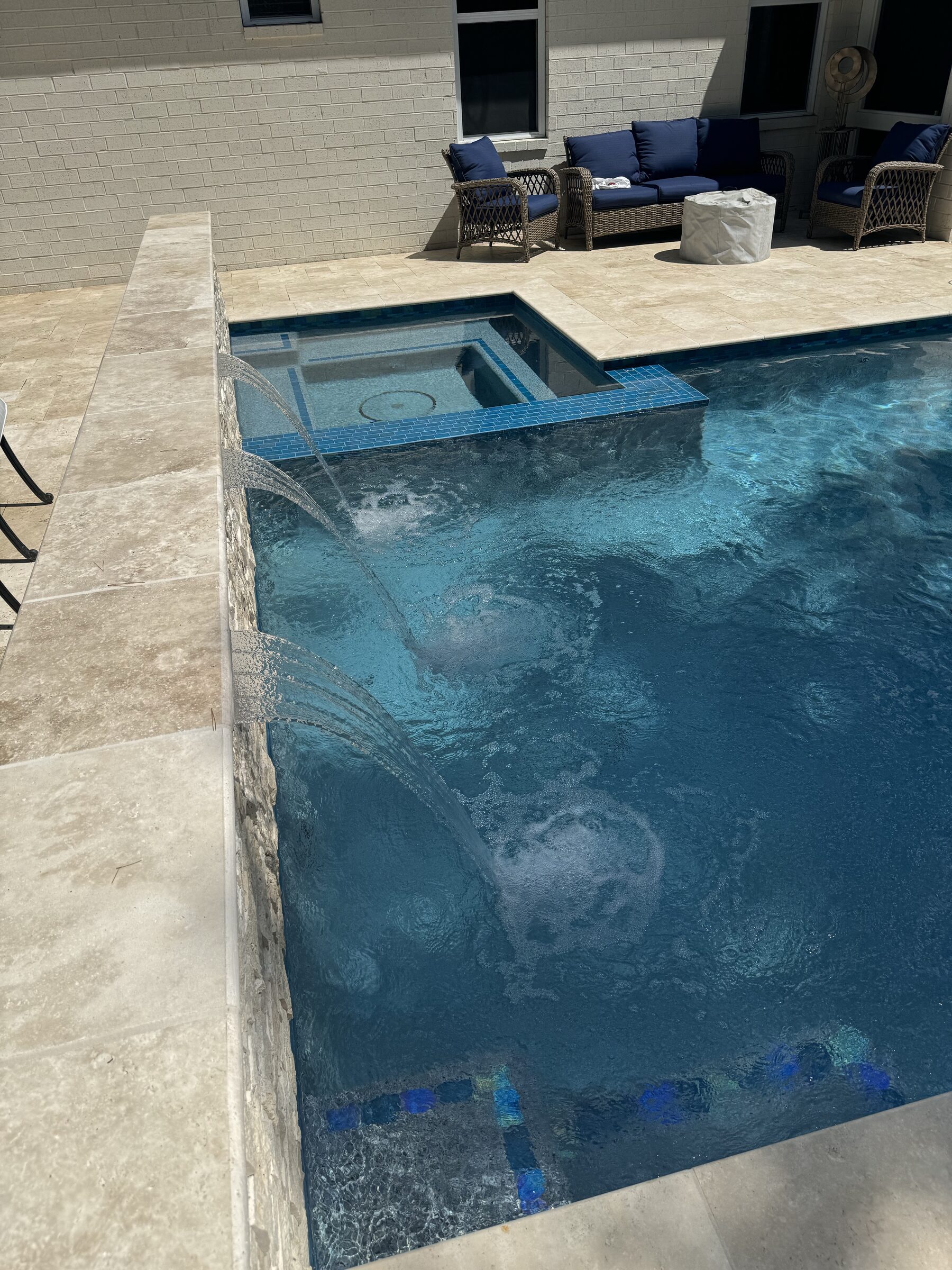 Pool and spa from the house — ivory travertine and blue water