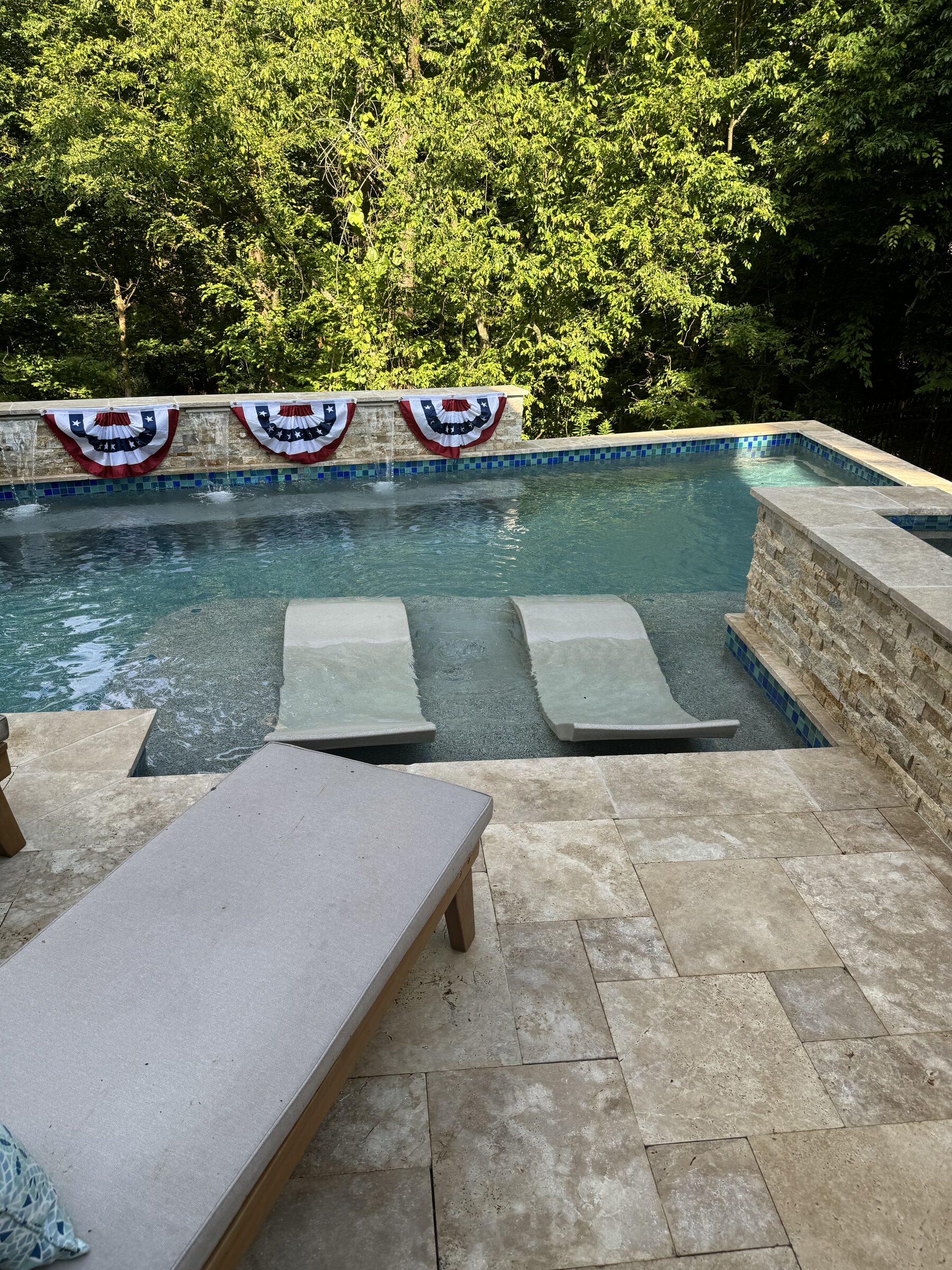 Poolside view — poured staircase and 4th of July flags