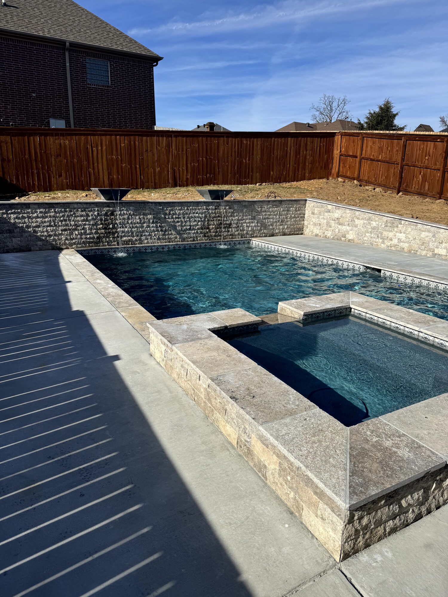 Raised spa with pattern tile and travertine