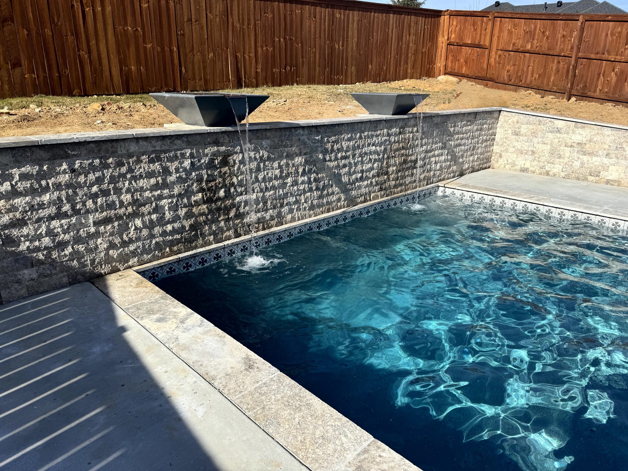 Split-face travertine retaining wall with custom water bowls